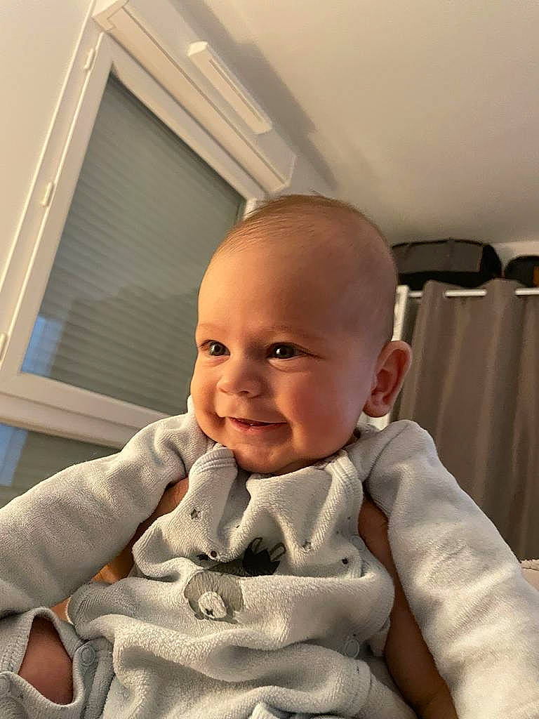 Loann a rejoint le concours — aidez-le/la à gagner de superbes lots ! baby, baby_toddler_clothing, cheek, child, chin, comfort, finger, fun, gesture, happy, nail, pattern, person, room, sitting, skin, sleeve, smile, thumb, toddler