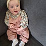 baby, infant, child, couch, headband, blue_eyes, pink_overalls, floral_shirt, socks, cute, seated, indoors, portrait, soft_lighting, young_child, person, smiling, cozy, comfortable, fashion