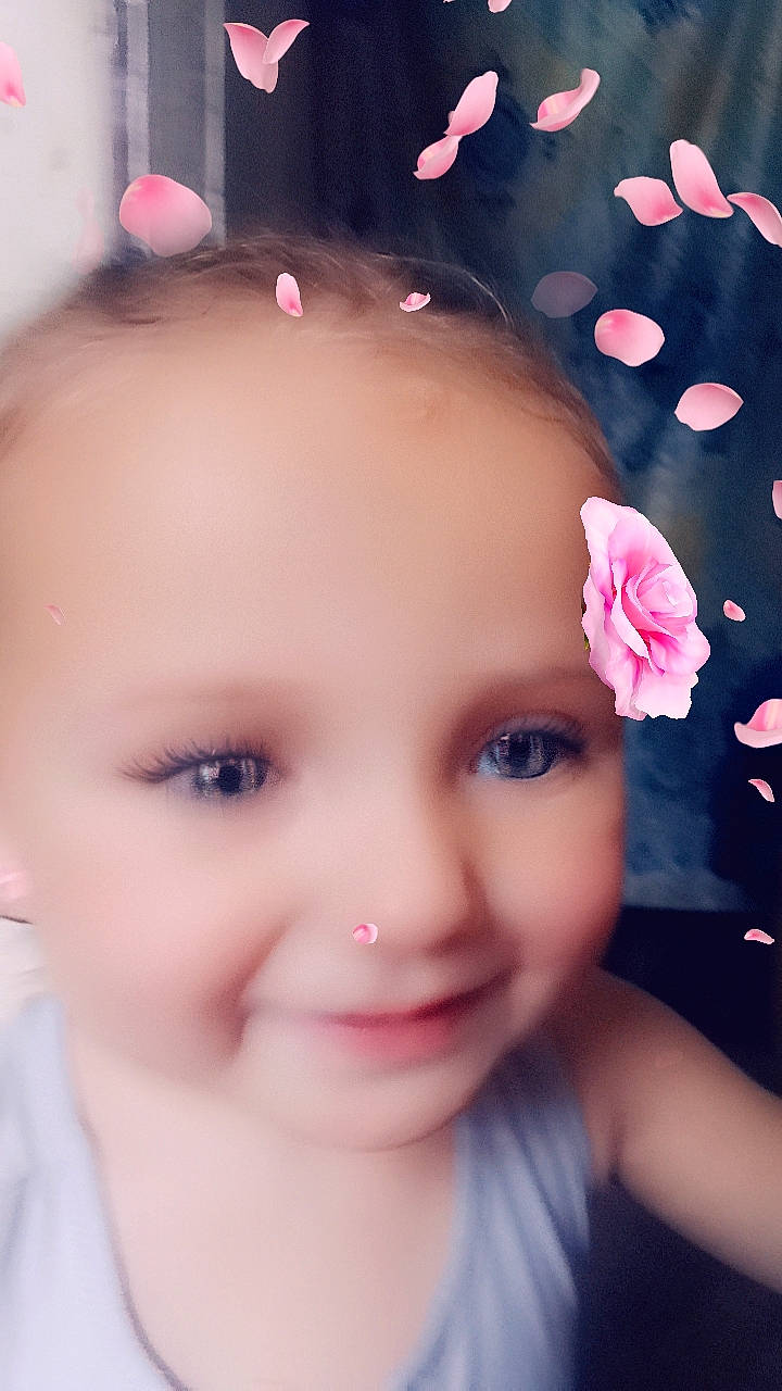 Isabella is registered to the contest to win money with this photo: cheek, chin, cool, ear, eyebrow, eyelash, face, flash_photography, flower, forehead, happy, headgear, joy, lip, neck, nose, person, petal, pink, plant