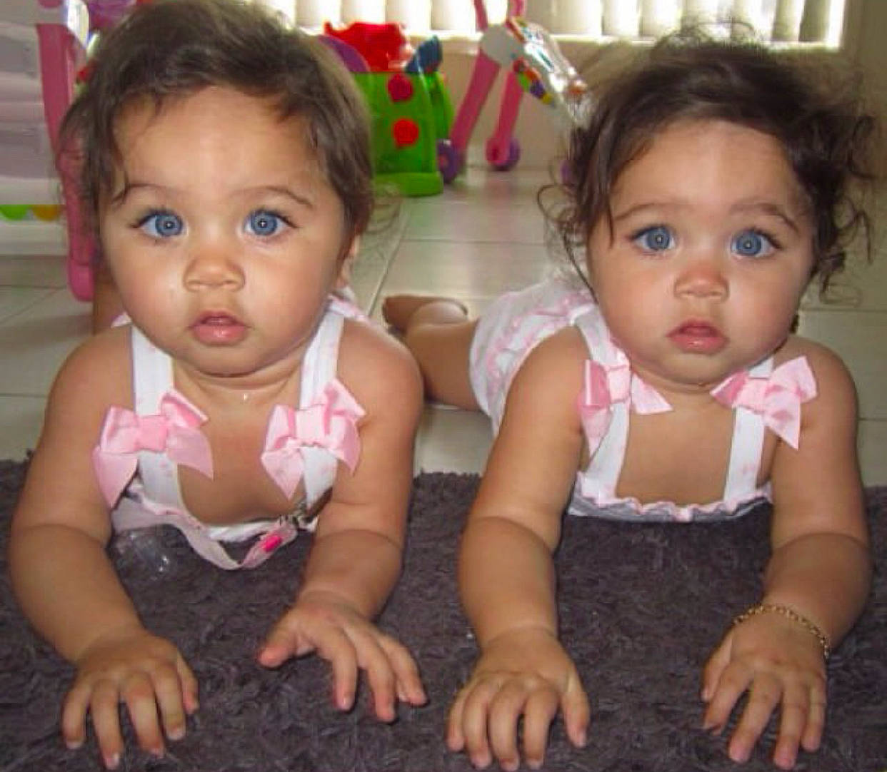 Bella And Mia is registered to the contest to win money with this photo: baby, baby_toddler_clothing, cheek, chin, dress, facial_expression, finger, hair, hairstyle, happy, human_body, iris, lip, mouth, nose, person, pink, sharing, skin, standing