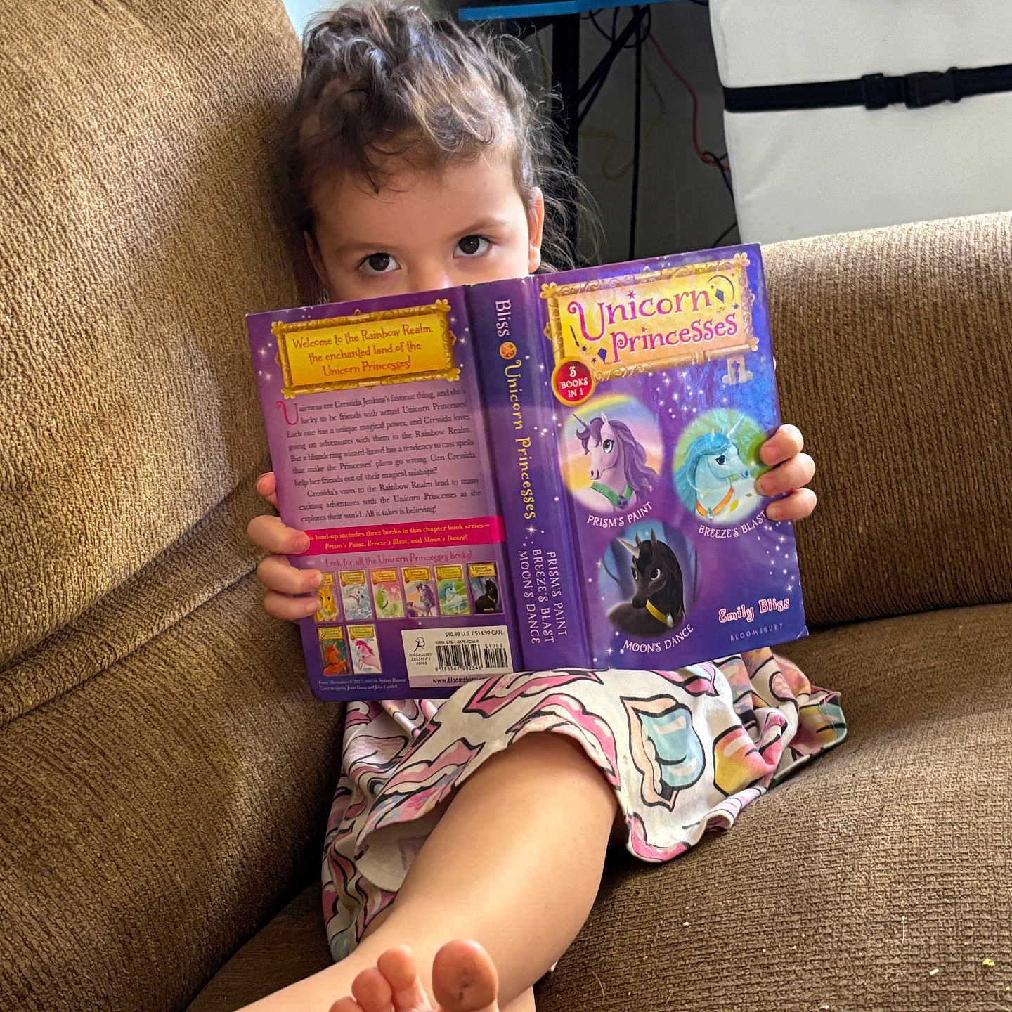 Sophie is registered to the contest to win money with this photo: animal, barefoot, bodypart, book, cat, child, couch, face, female, finger, furniture, girl, hand, head, person, pet, photography, portrait, publication, reading