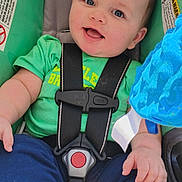 Karson is registered to the contest to win money with this photo: baby, child, car_seat, green_shirt, blue_pants, smiling, happy, infant, seatbelt, toy, blue_toy, cute, portrait, sitting, foot, hand, indoor, safety, young_child, face