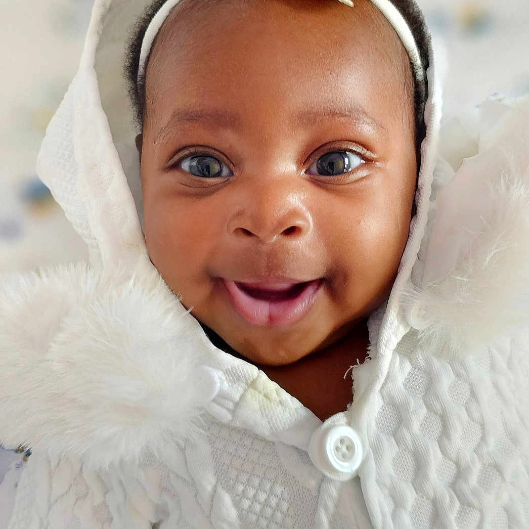 Peace joined the competition — help win amazing prizes! adorable, baby, buttoned_clothing, child, close_up, cute, eyes, face, flower, happy, headband, hood, indoor, infant, knitwear, portrait, smiling, soft_texture, warm, white_clothing