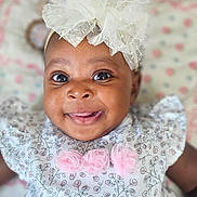 Peace is registered to the contest to win money with this photo: adorable, baby, bow, cheerful, child, closeup, cute, dress, face, floral_pattern, happy, headband, indoors, infant, person, pink, portrait, smile, white, young