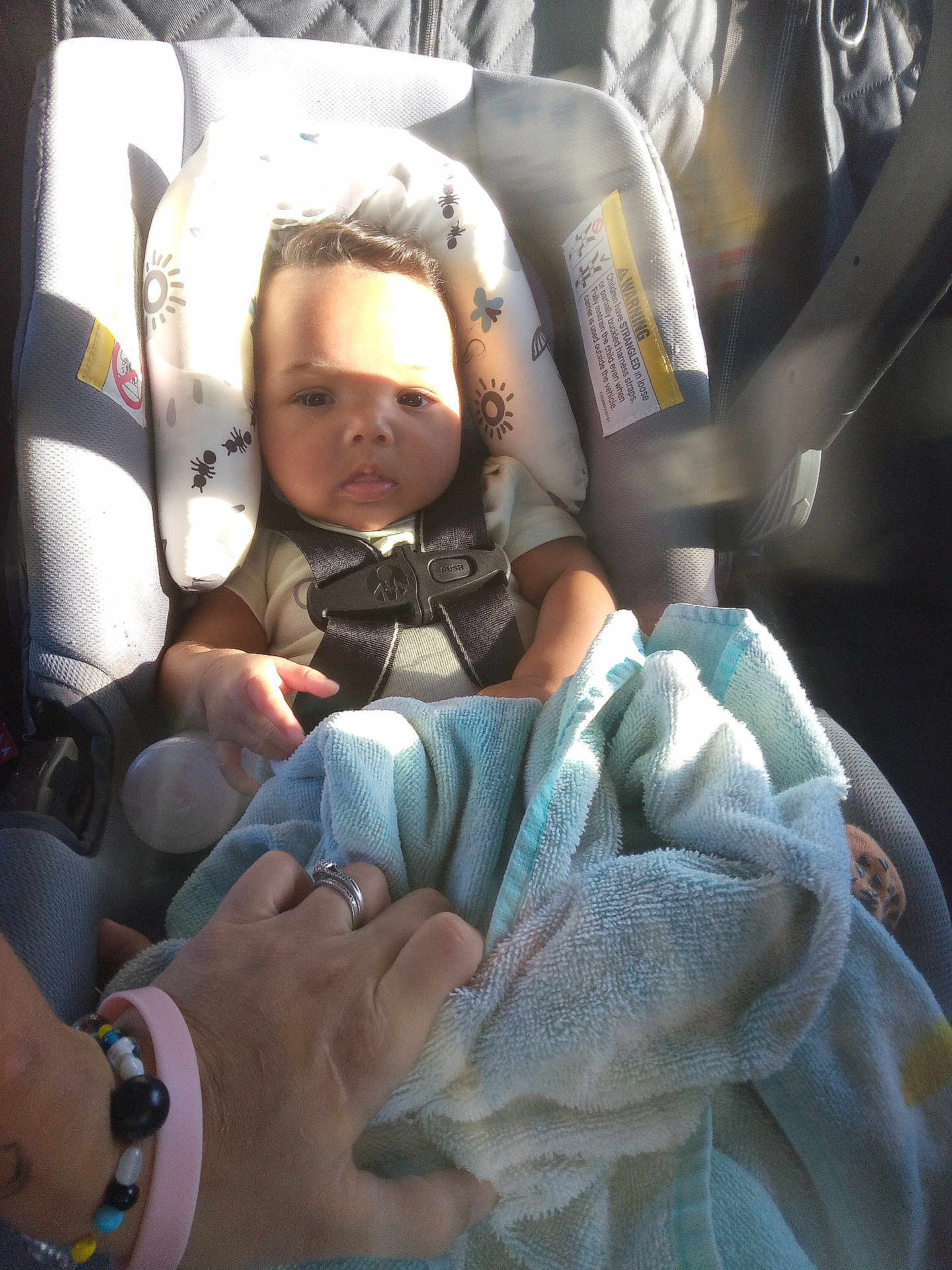 Lyric is registered to the contest to win money with this photo: baby, car_seat, child, seatbelt, hand, towel, sunlight, shadow, interior, car, person, ring, bracelet, protection, infant, clothing, seat, safety, comfort, human