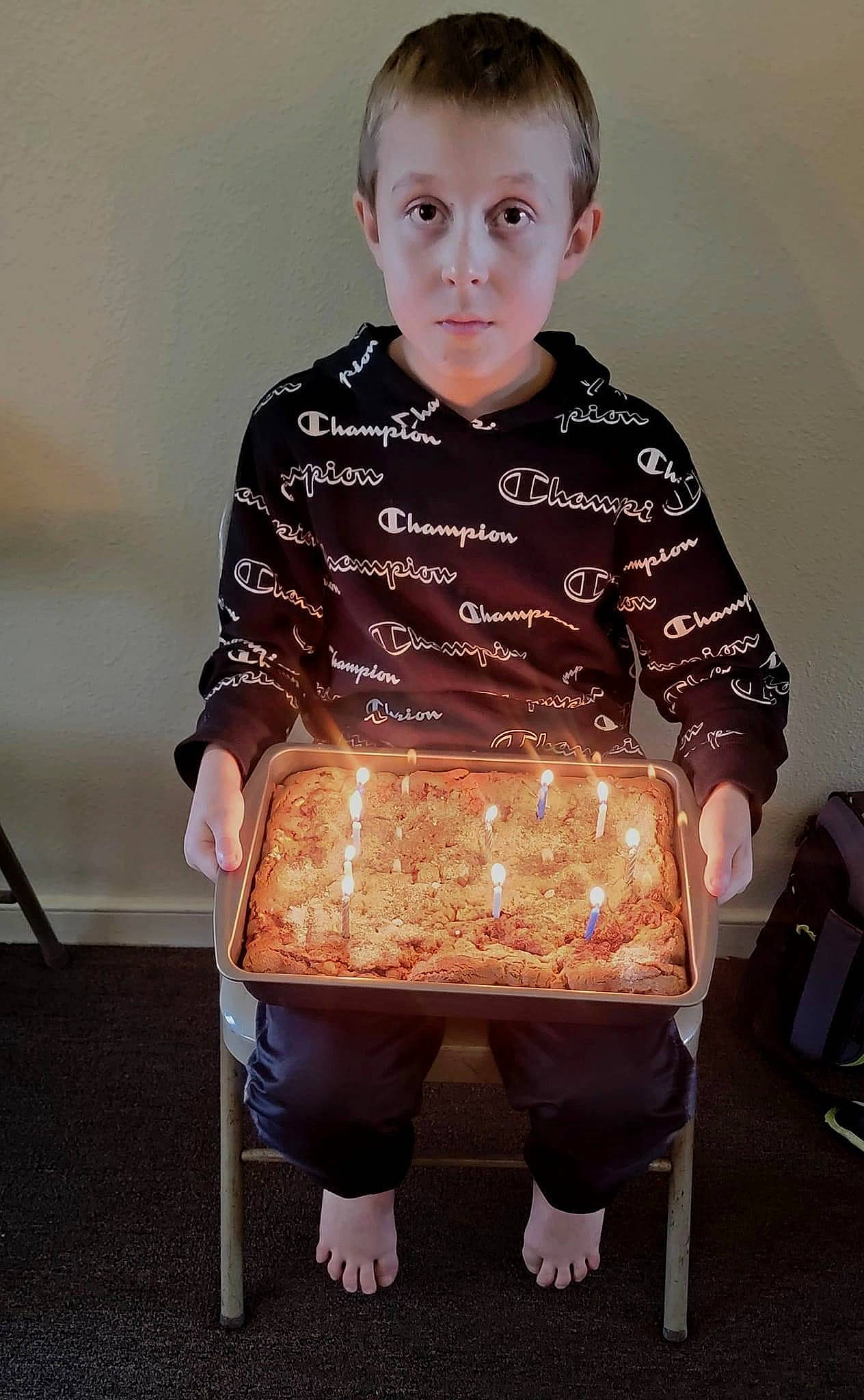 Devin is registered to the contest to win money with this photo: baby_products, baby_toddler_clothing, bag, chair, child, collar, dress_shirt, fashion_accessory, flooring, fun, fur, hairstyle, pattern, person, play, sitting, sleeve, t_shirt, toddler, top