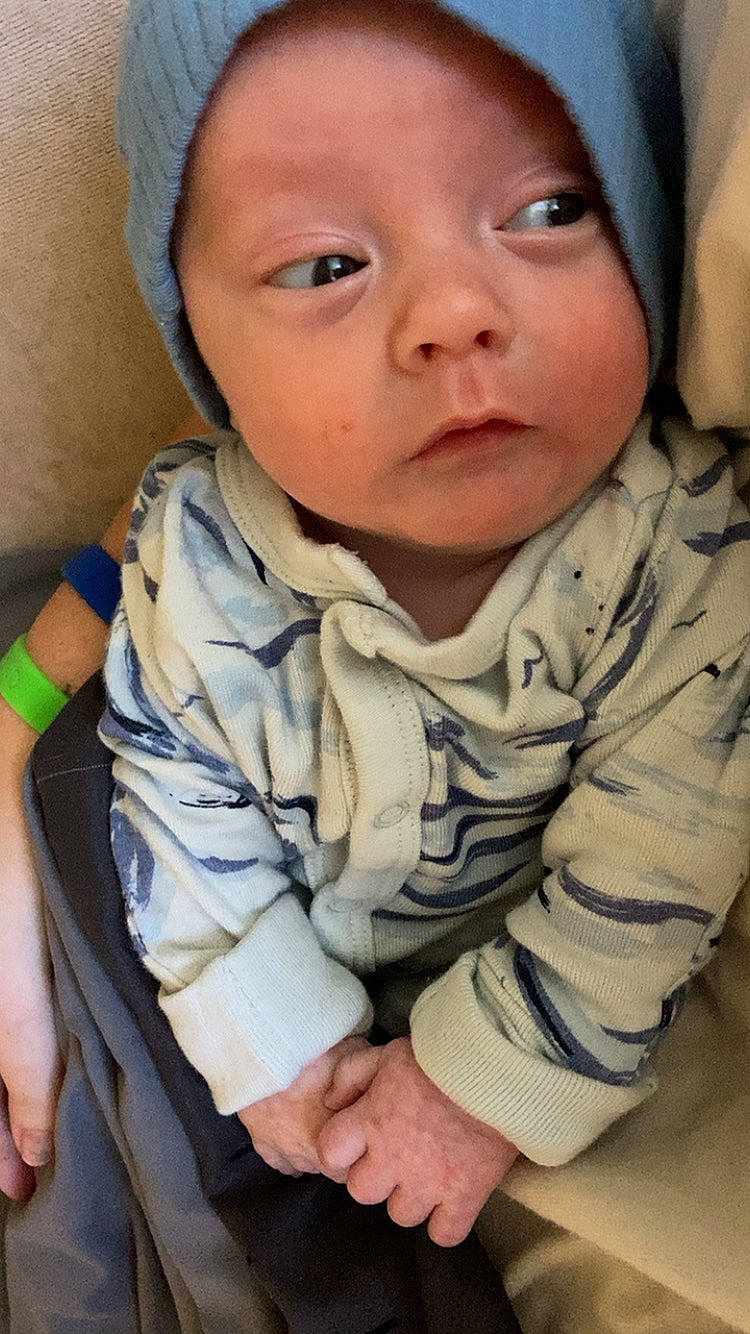 Kaden is registered to the contest to win money with this photo: baby, baby_toddler_clothing, cap, cheek, chin, comfort, cool, eyebrow, face, facial_expression, finger, gesture, headwear, human, iris, lip, mouth, neck, nose, person