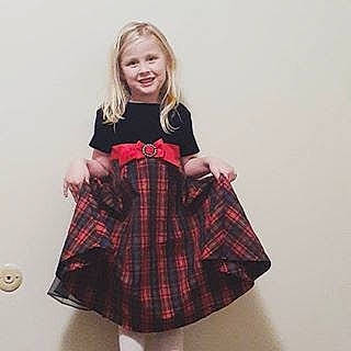 Ali is registered to the contest to win money with this photo: a_line, child, child_model, clothing, costume, design, dress, joy, kilt, outerwear, pattern, person, plaid, sleeve, tartan, textile, toddler