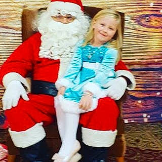 Ali is registered to the contest to win money with this photo: beard, child, christmas, christmas_eve, costume, facial_hair, fictional_character, happy, holiday, human_body, joy, lap, leg, person, santa_claus, smile, toddler