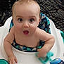 baby, child, high_chair, toy, indoor, person, seat, furniture, patterned_cushion, blue, skin, hand, expression, face, mouth_open, eyes, young, infant, curious, candid