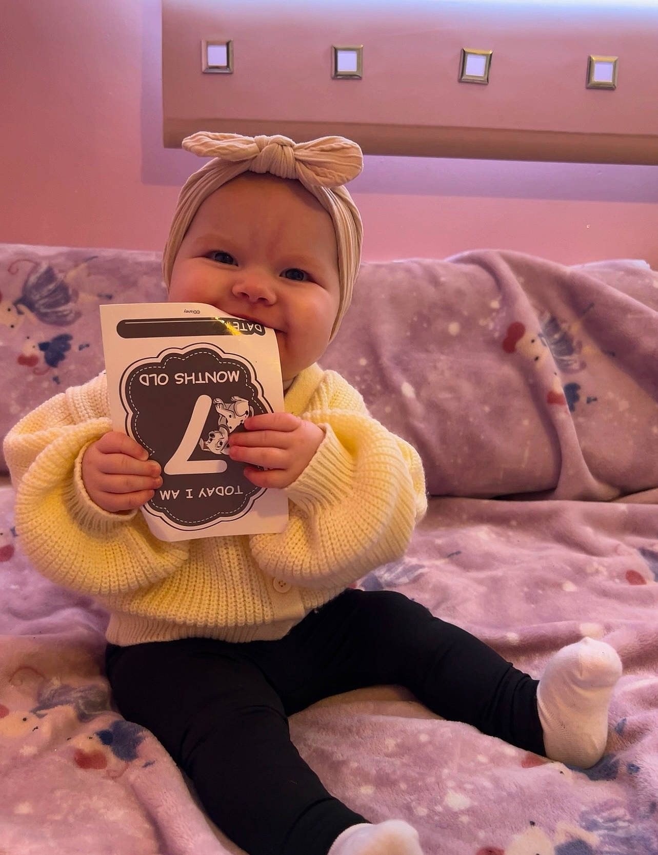 Laila is registered to the contest to win money with this photo: baby_toddler_clothing, cheek, child, comfort, couch, drinkware, flooring, fun, happy, headwear, linens, nail, person, pink, room, sitting, skin, sleeve, sweetness, television