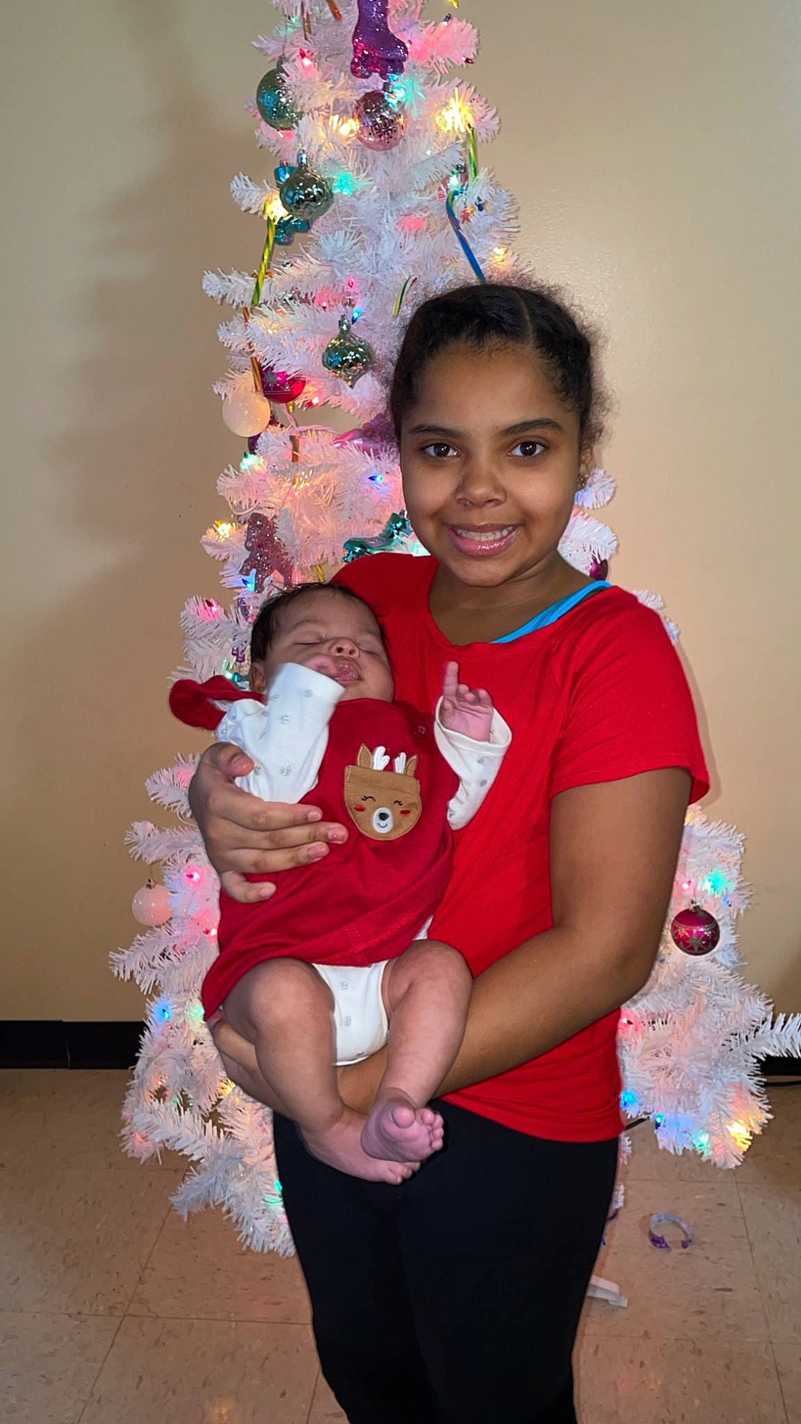Isabella joined the competition — help win amazing prizes! abdomen, child, christmas_tree, event, fun, happy, holiday, jewellery, joy, magenta, ornament, person, pink, shorts, sitting, sleeve, smile, t_shirt, textile, toddler