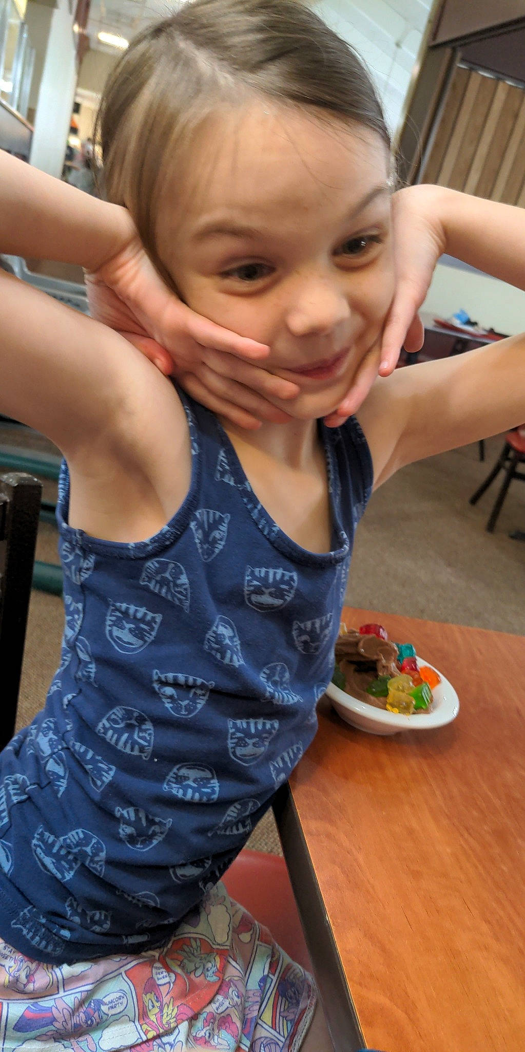 Ashlynn is registered to the contest to win money with this photo: arm, chair, child, face, finger, food, food_craving, hand, happy, ingredient, leisure, person, plate, skin, smile, summer, t_shirt, table, tableware, thumb