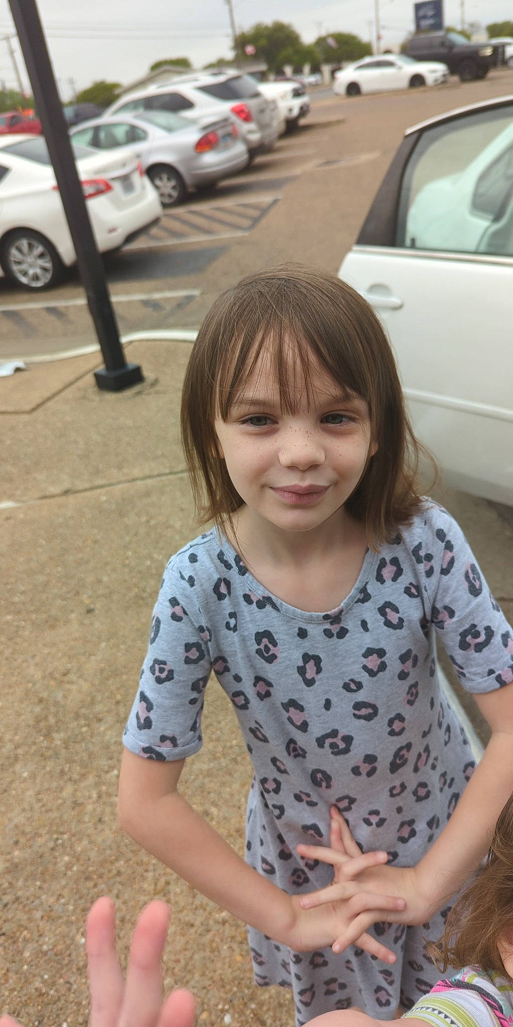 Ashlynn is registered to the contest to win money with this photo: asphalt, automotive_tire, car, cool, dress, face, facial_expression, happy, head, joy, land_vehicle, mammal, motor_vehicle, person, sleeve, street_fashion, t_shirt, tire, toddler, vehicle_door