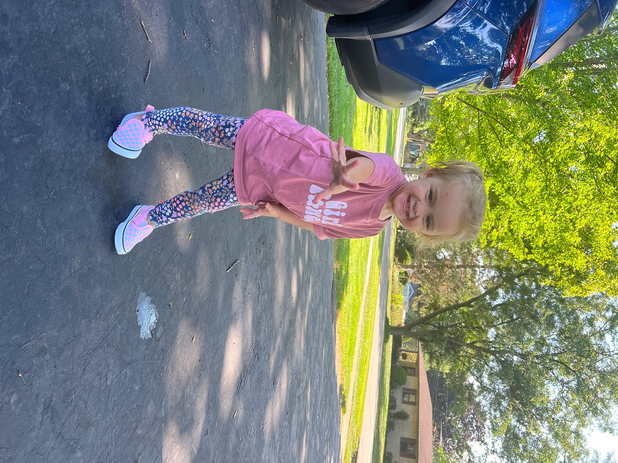 Maya is registered to the contest to win money with this photo: asphalt, electric_blue, fun, grass, happy, hat, joy, leisure, magenta, people_in_nature, person, plant, recreation, red, road_surface, shadow, sky, t_shirt, tints_and_shades, toddler