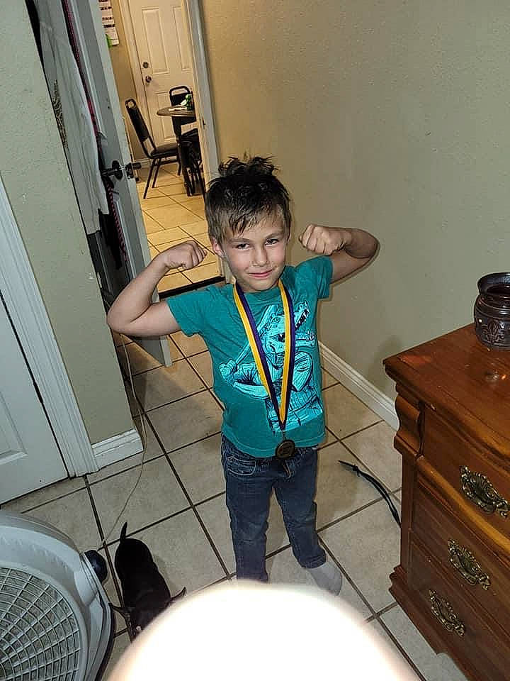 Levii is registered to the contest to win money with this photo: cabinetry, chair, chest, chest_of_drawers, cupboard, door, drawer, dresser, elbow, fun, hardwood, joy, leg, nightstand, person, room, shorts, sneakers, standing, t_shirt