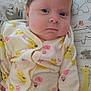 Zoey joined the competition — help win amazing prizes! baby, infant, onesie, pillow, animal_print, sloth, elephant, giraffe, face, expression, clothing, cute, child, indoors, portrait, sleepwear, newborn, person, pattern, soft