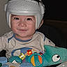toddler, child, helmet, smile, face, toy, plush_toy, activity_center, xylophone, colorful, indoor, clothing, happy, person, infant, cute, baby, playtime, headgear, seated