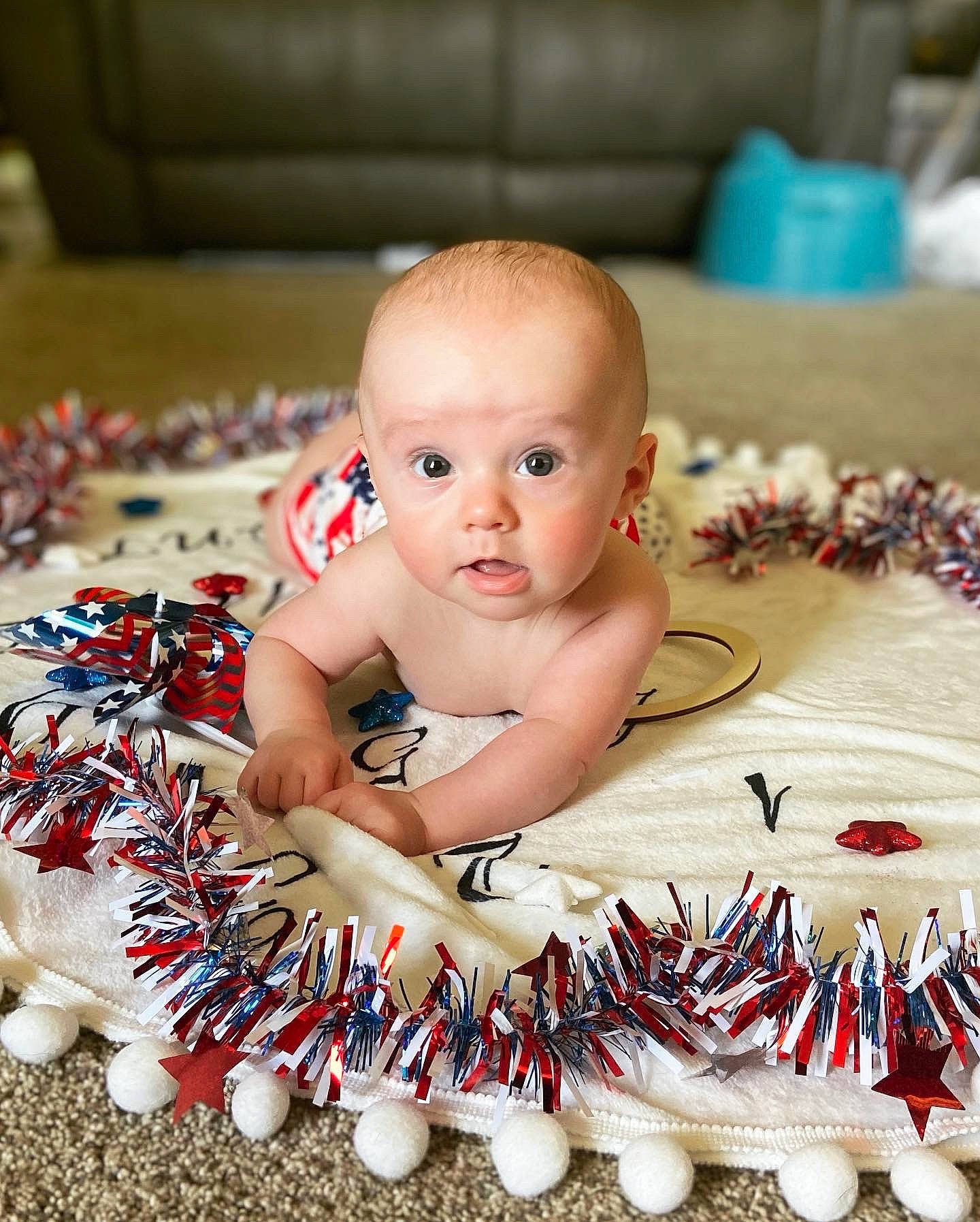 Callum is registered to the contest to win money with this photo: baby, baby_products, baby_toddler_clothing, cheek, child, event, eye, flooring, fun, happy, head, holiday, nail, party_supply, person, play, sitting, sweetness, toddler, toy