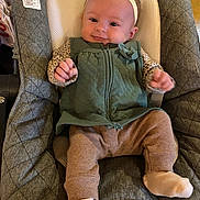 Violet joined the competition — help win amazing prizes! baby, infant, child, green_vest, leopard_print, headband, baby_seat, cushion, white_socks, smiling, indoor, clothing, cute, portrait, baby_toys, fabric, seat, hands, feet, comfort
