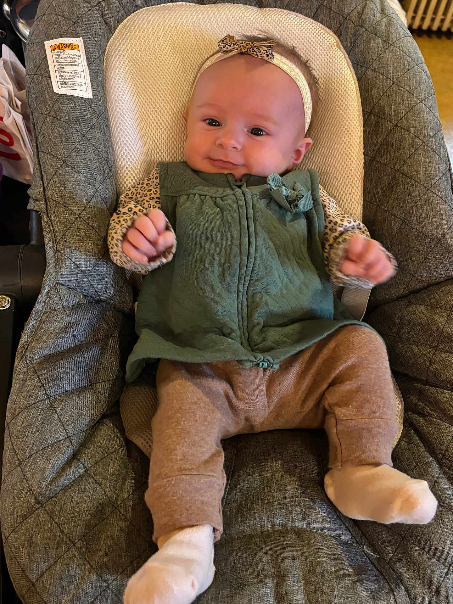 Violet joined the competition — help win amazing prizes! baby, infant, child, green_vest, leopard_print, headband, baby_seat, cushion, white_socks, smiling, indoor, clothing, cute, portrait, baby_toys, fabric, seat, hands, feet, comfort