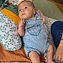 Eléanore participe au concours pour gagner de l'argent avec cette photo : baby, denim_overalls, heart_pocket, blanket, pillow, leaf_pattern, infant, lying_down, curious_expression, natural_light, person_arm, casual_clothing, indoor, soft_lighting, cute, child, skin, foot, hand, fabric