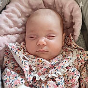 Eléanore participe au concours pour gagner de l'argent avec cette photo : baby, sleeping, infant, floral_clothing, cushion, blanket, soft_texture, star_pattern, cute, peaceful, indoors, close_up, hand, portrait, child, newborn, cozy, comfortable, rest, adorable