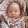 baby, sleeping, infant, floral_clothing, cushion, blanket, soft_texture, star_pattern, cute, peaceful, indoors, close_up, hand, portrait, child, newborn, cozy, comfortable, rest, adorable