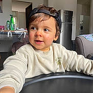 Tao a rejoint le concours — aidez-le/la à gagner de superbes lots ! child, toddler, cap, baseball_cap, sweatshirt, highchair, tray, kitchen, refrigerator, bottle, cup, smiling, face, portrait, indoor, arm, curious, cheeks, home, furniture