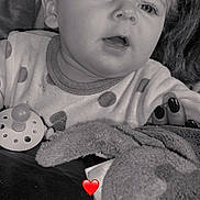 Shelby participe au concours pour gagner de l'argent avec cette photo : baby, child, face, pacifier, plush_toy, hand, curly_hair, clothing, black_and_white, portrait, close_up, infant, expression, cute, soft_texture, person, indoor, young_child, holding, nurturing