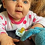 baby, child, blue_eyes, polka_dot, pacifier, toy, hand, curly_hair, face, infant, cute, indoor, closeup, expression, soft_toy, clothing, person, portrait, skin, table