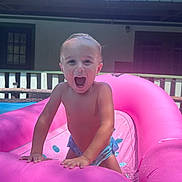 Ej. is registered to the contest to win money with this photo: toddler, child, inflatable, pool, pink, water, summer, outdoor, play, happy, excited, splash, climbing, skin, sunlight, backyard, porch, daytime, fun, smile