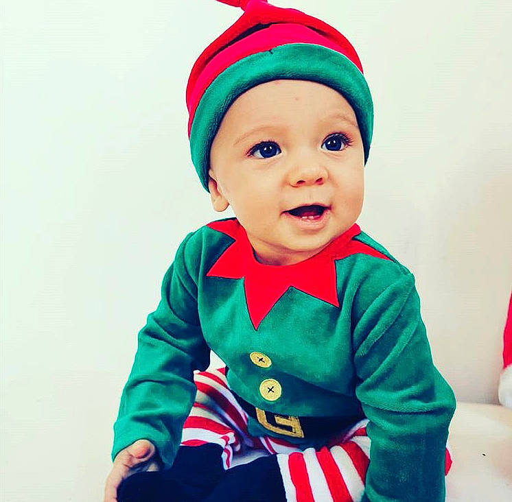 Charli a rejoint le concours — aidez-le/la à gagner de superbes lots ! baby, baby_toddler_clothing, bonnet, child, christmas, christmas_eve, costume, costume_accessory, costume_hat, fictional_character, headwear, holiday, nightwear, overall, party_supply, person, pleased, red, sleeve, toddler