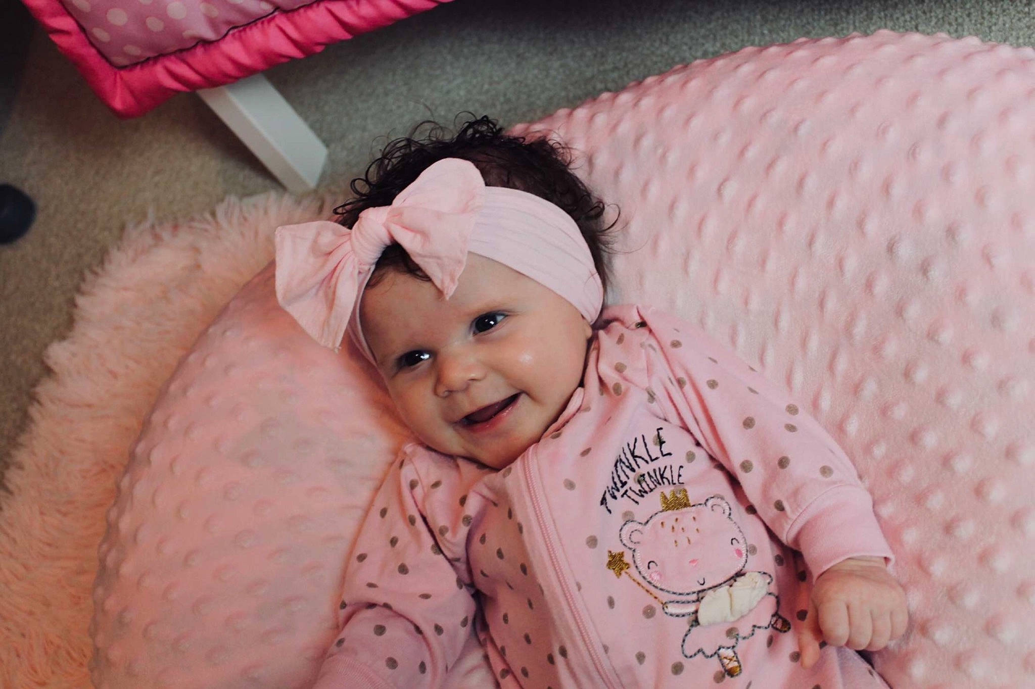 Leilani is registered to the contest to win money with this photo: baby, baby_toddler_clothing, cap, child, comfort, couch, event, eyelash, happy, head, headpiece, headwear, joy, linens, magenta, pattern, person, pink, skin, sleeve