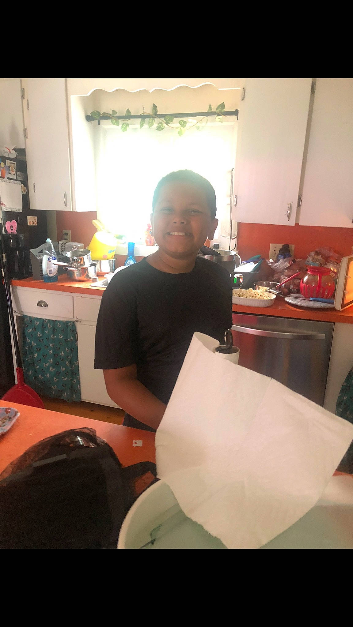 Liam is registered to the contest to win money with this photo: beard, desk, event, eyewear, facial_hair, fun, joy, person, room, sitting, sleeve, smile, t_shirt, table, top, vision_care