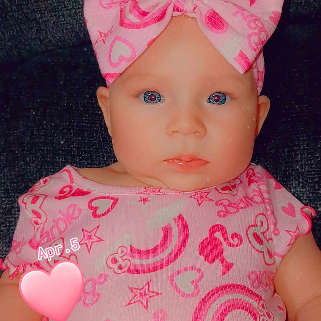 Sophia is registered to the contest to win money with this photo: baby, infant, pink_bow, pink_clothing, rainbow_pattern, heart_pattern, stars, portrait, close_up, child, cute, tutu_skirt, headband, sitting, indoor, face, eyes, skin, expression, adorable
