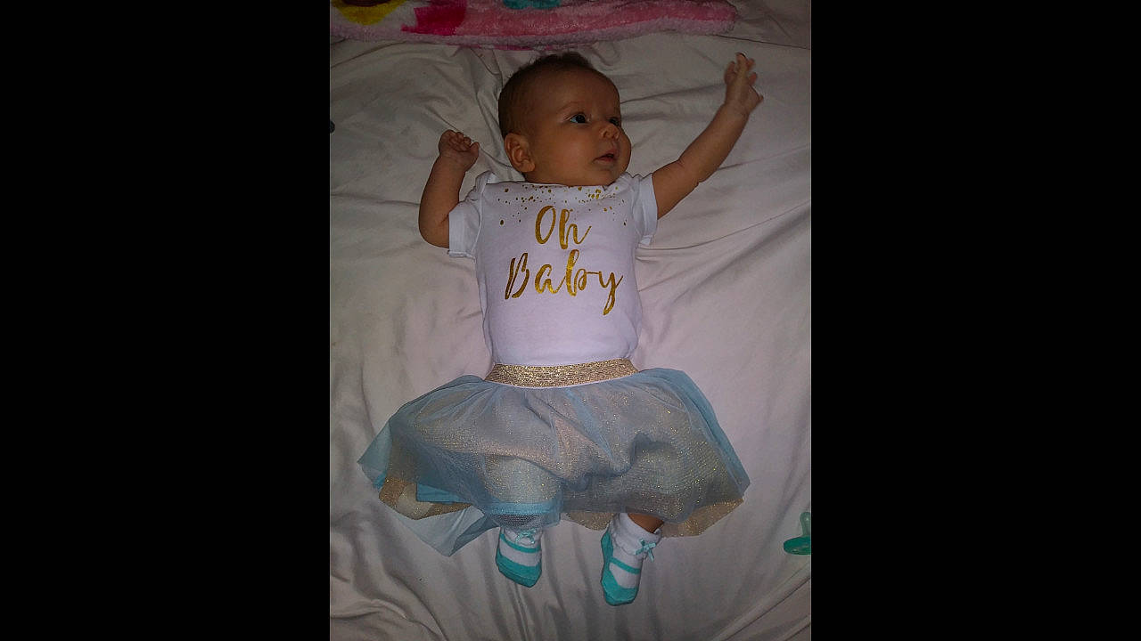 Alia is registered to the contest to win money with this photo: beauty, blue, child, day, eye, face, facial_expression, fun, girl, head, infant, person, pink, product, sitting, skin, smile, textile, toddler, white