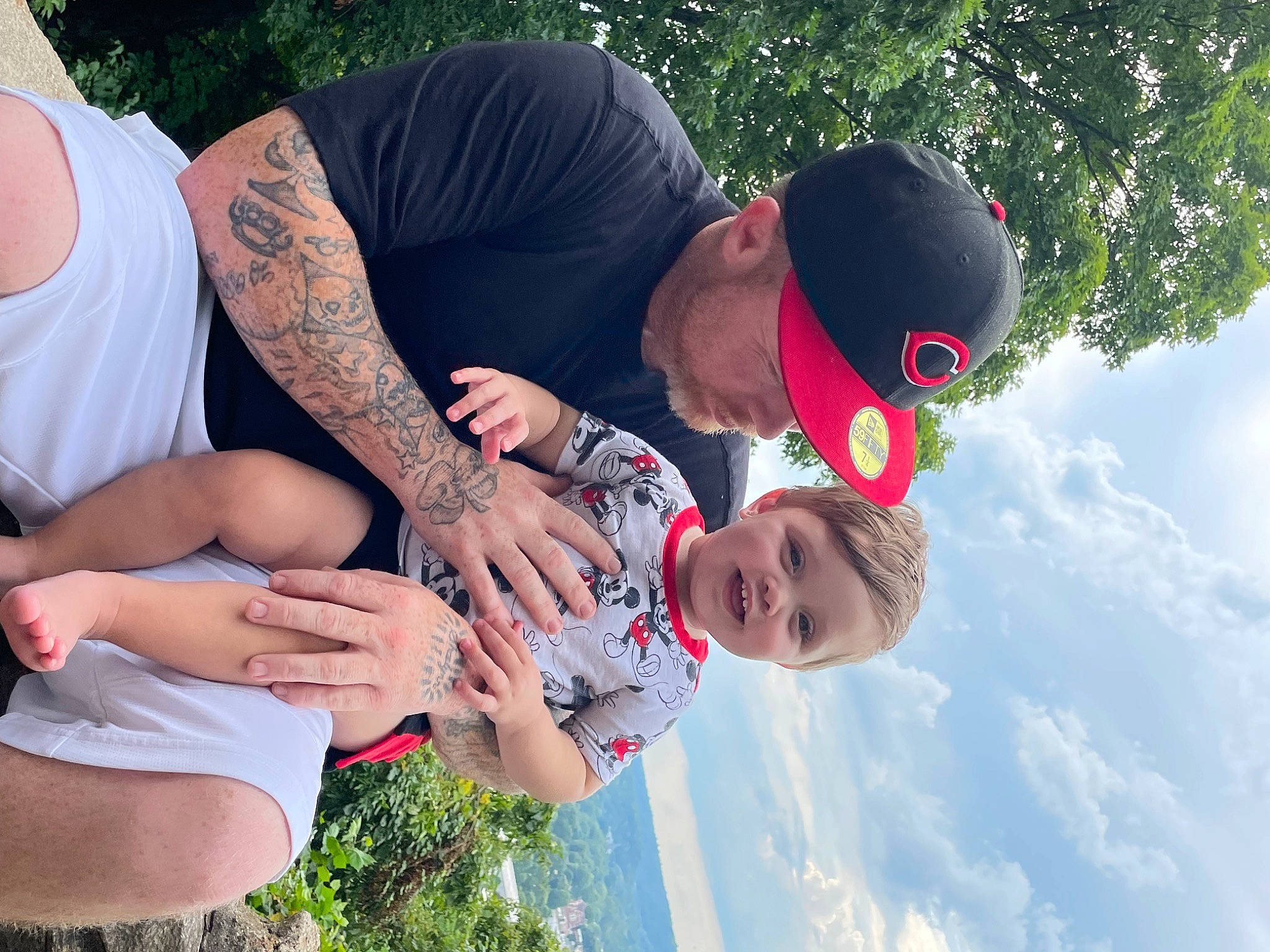 Braxton is registered to the contest to win money with this photo: baseball_cap, cap, cloud, event, fun, gesture, grass, happy, hat, headwear, leaf, leisure, people_in_nature, person, plant, recreation, shorts, sky, sun_hat, thigh