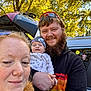 Odin is registered to the contest to win money with this photo: family, woman, man, baby, outdoor, autumn, trees, car, trunk, beard, hat, clothing, smile, holding, nature, daylight, portrait, people, casual, happy