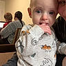 baby, child, adult, indoor, family, pajamas, dinosaur_print, lap, hand, fingers, blue_eyes, curious, seated, sweater, laptop, back_view, brown_hair, watch, woman, cozy