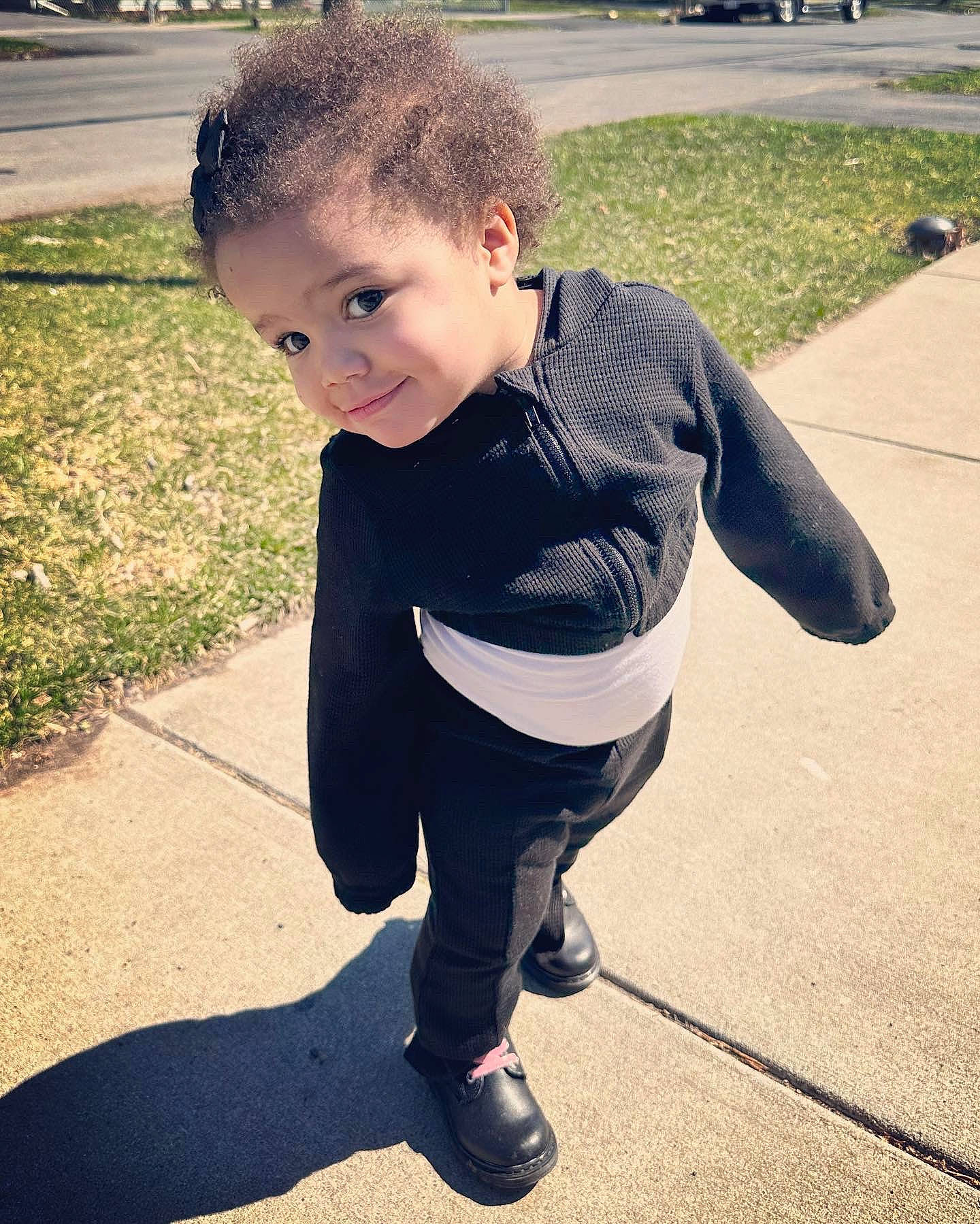 Mylah is registered to the contest to win money with this photo: asphalt, cool, denim, electric_blue, flooring, grass, happy, human_body, person, plant, public_space, recreation, shoe, sleeve, smile, sneakers, sportswear, t_shirt, tints_and_shades, toddler