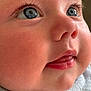 baby, close_up, face, blue_eyes, cheeks, tongue, skin, eyelashes, nose, mouth, infant, cute, soft, texture, fabric, expression, human, portrait, child, adorable