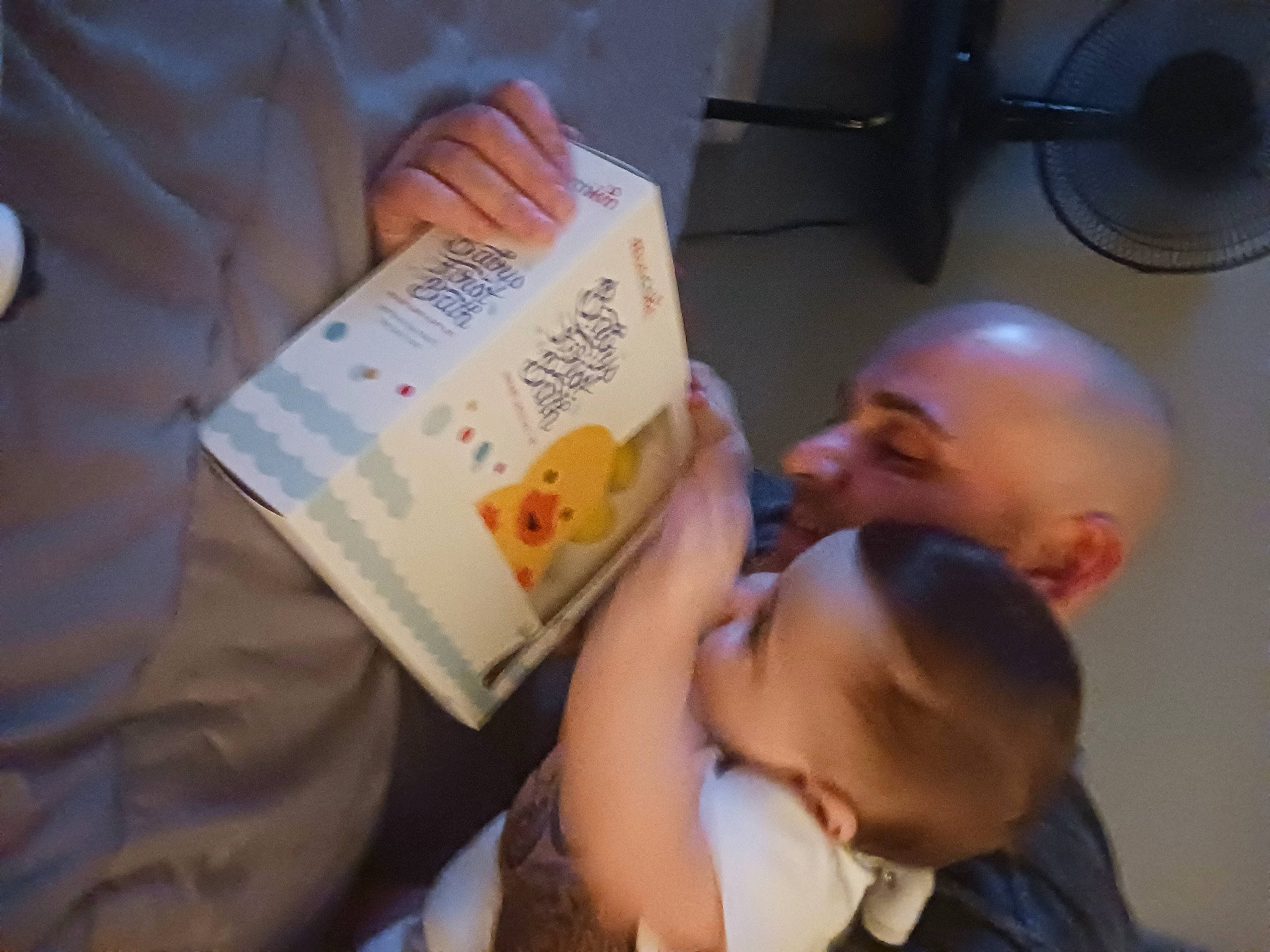 Calvin is registered to the contest to win money with this photo: audio_equipment, baby, book, child, ear, event, finger, font, fun, gesture, hand, happy, mechanical_fan, nail, person, publication, reading, room, smile, toddler