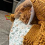 cat, ginger_cat, sleeping, cone, protective_collar, blanket, knit_blanket, floral_pattern, bed, indoor, cozy, pet, resting, closeup, feline, cute, domestic_animal, soft_texture, comfort, animal