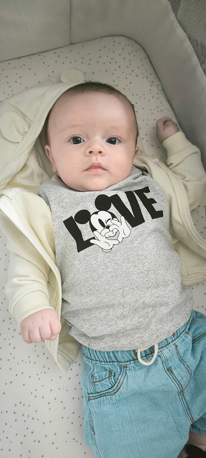 Morgan participe au concours pour gagner de l'argent avec cette photo : baby, child, clothing, crib, cute, denim_shorts, eyes, fabric, face, hand, hoodie, indoor, infant, love_text, mickey_mouse, pale_colors, pattern, person, portrait, soft_lighting