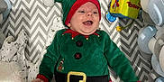 Jürgen a rejoint le concours — aidez-le/la à gagner de superbes lots ! baby, infant, smiling, christmas_outfit, elf_costume, striped_pants, crib, blanket, toy, soft_cushions, happy, holiday, festive, red_and_green, plush, cute, child, indoors, cheerful, lying_down