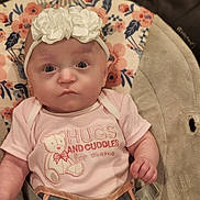 Emery Rose is registered to the contest to win money with this photo: baby, infant, headband, flower, pink_onesie, baby_seat, floral_pattern, straps, closeup, face, eyes, cute, child, portrait, indoor, soft_lighting, expression, clothing, newborn, babytrend