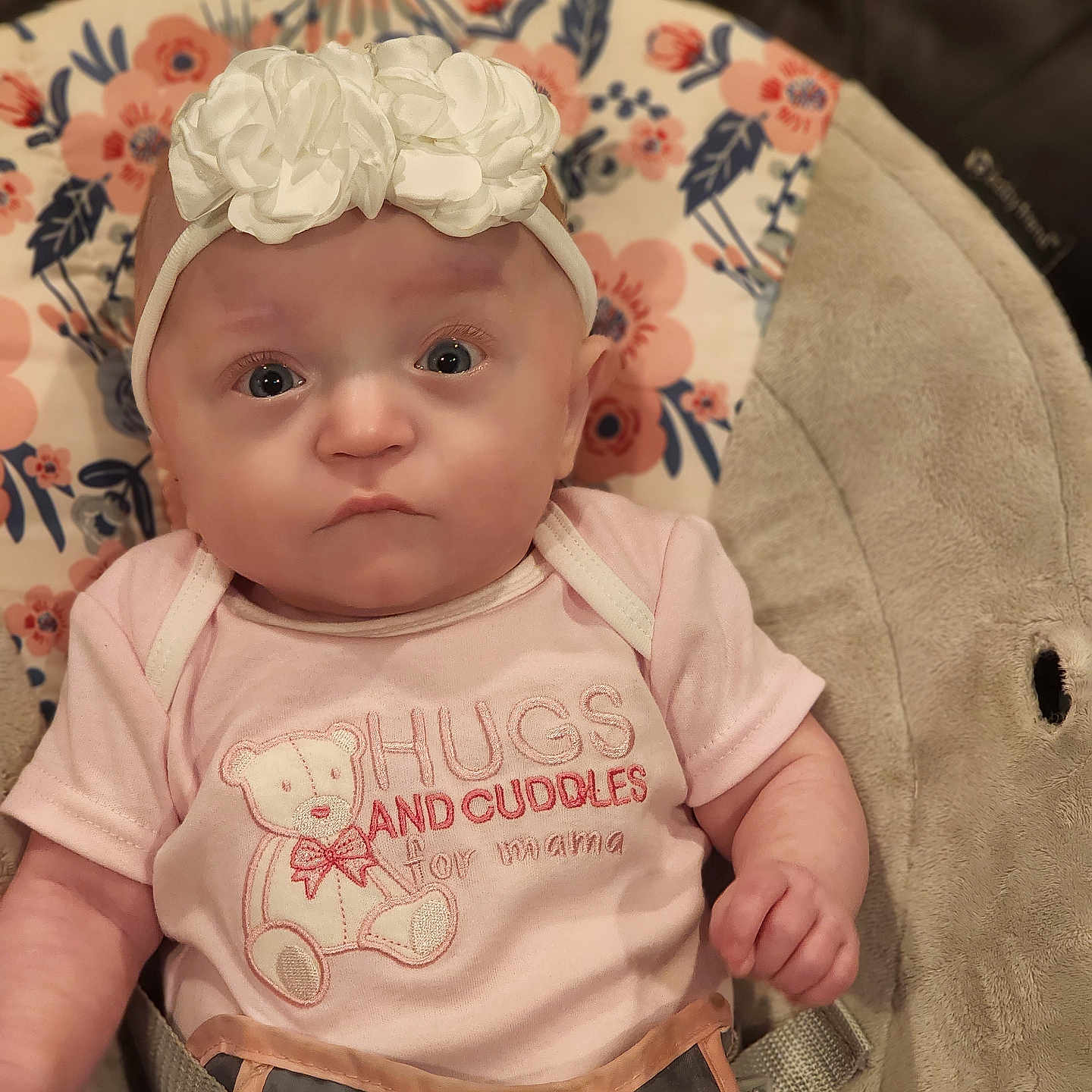 Emery Rose is registered to the contest to win money with this photo: baby, baby_seat, babytrend, child, closeup, clothing, cute, expression, eyes, face, floral_pattern, flower, headband, indoor, infant, newborn, pink_onesie, portrait, soft_lighting, straps