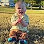 baby, child, happy, smiling, clapping, grass, outdoor, sunlight, shirt, pants, socks, nature, park, daylight, person, cute, young_child, casual_clothing, sitting, face