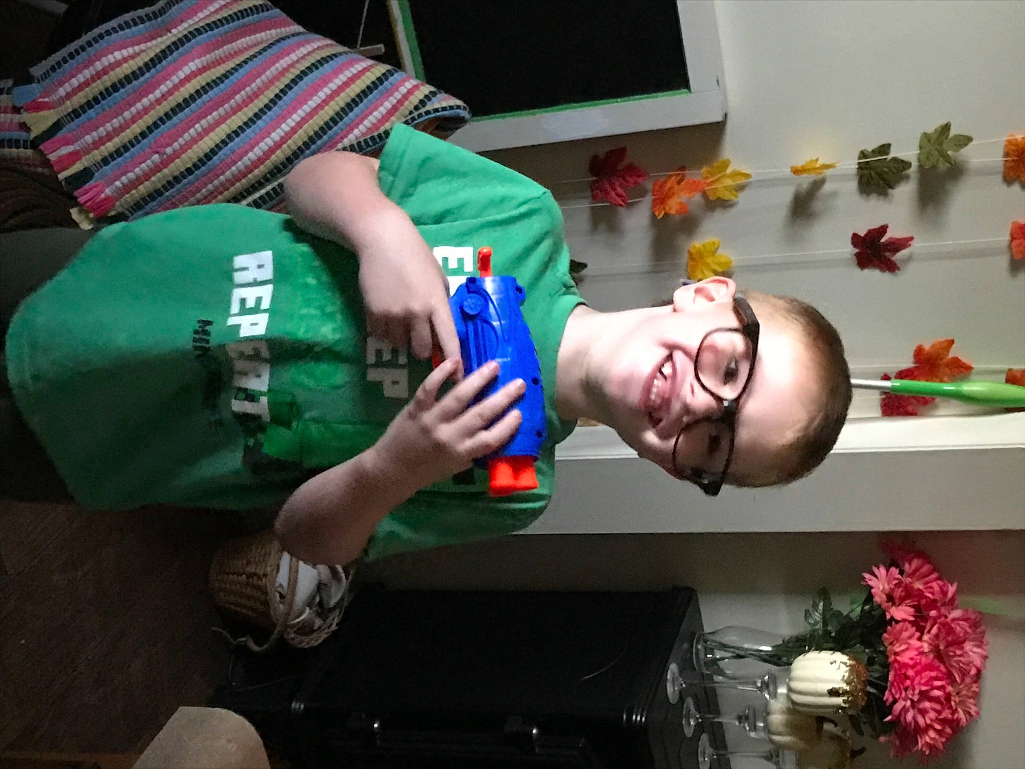 Gunner is registered to the contest to win money with this photo: artificial_flower, cut_flowers, display_device, fictional_character, flower_arranging, humour, joy, mouth, person, television, television_set, thumb, tooth, toy, wrist